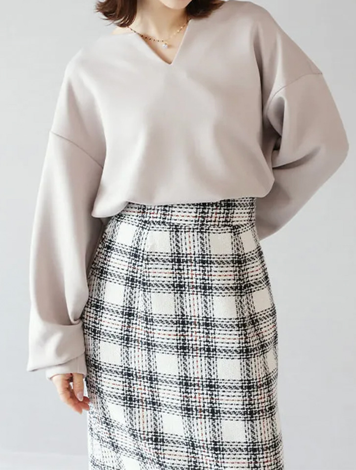 首元がスッキリ見えるダンボールキーネックトップスとチェック柄スカートを合わせた、春のきれいめ通勤コーデ