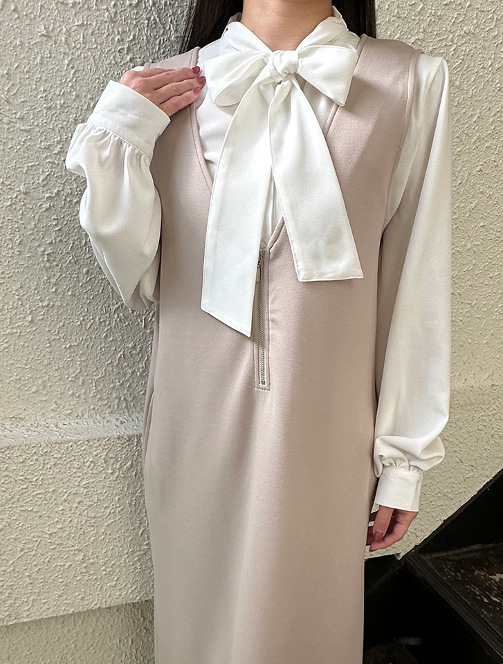 ポケット付きフロントファスナーダンボールジャンパースカートとボウタイブラウスを合わせた、上品な春の先取りスタイル